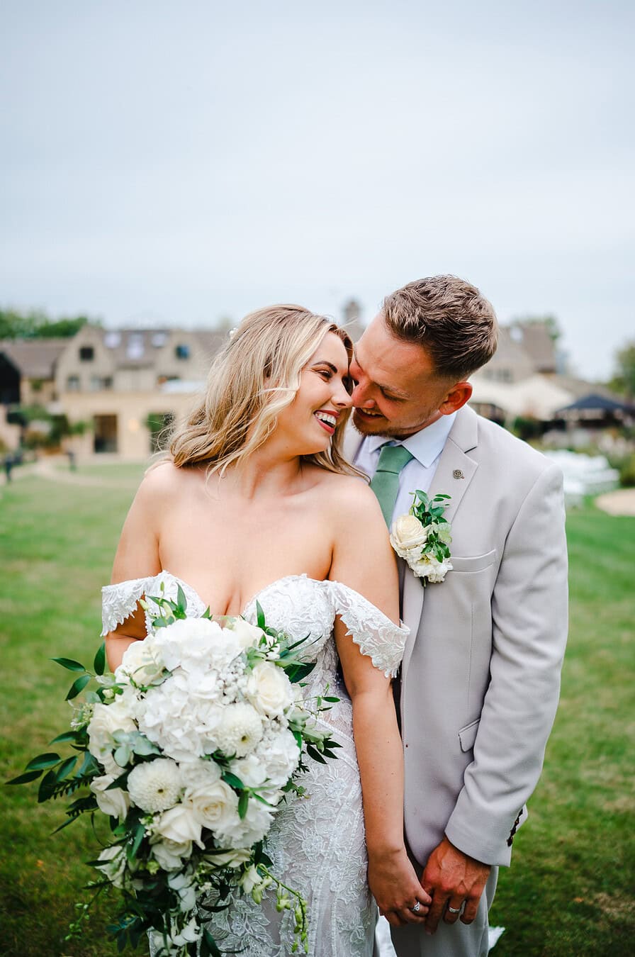 The wedding couple hold hands and get close with big grins across the newlyweds faces by Bath Wedding Photographer, Jake Timms Photography
