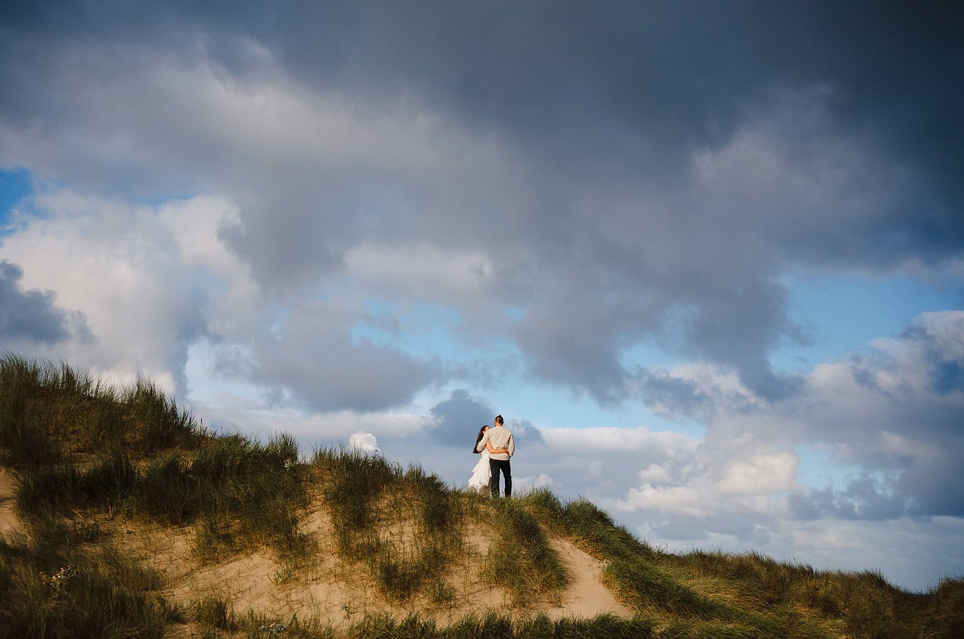 Standing up on the sand dunes at Holywell Bay celebrating your elopement wedding day in Cornwall - Elopement Portfolio