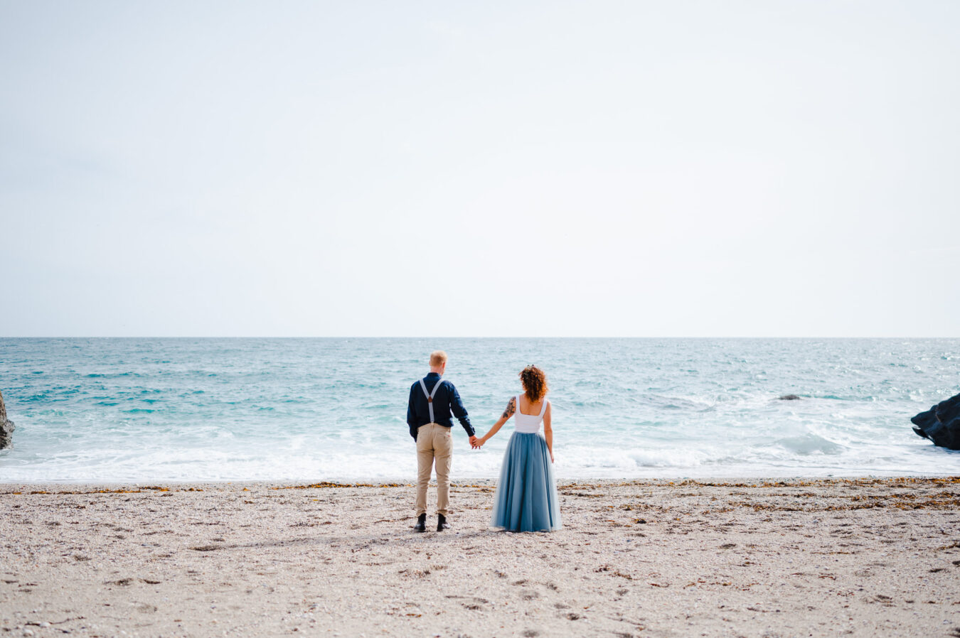 Holding hands and taking in the sea views whilst celebrating getting married in Cornwall