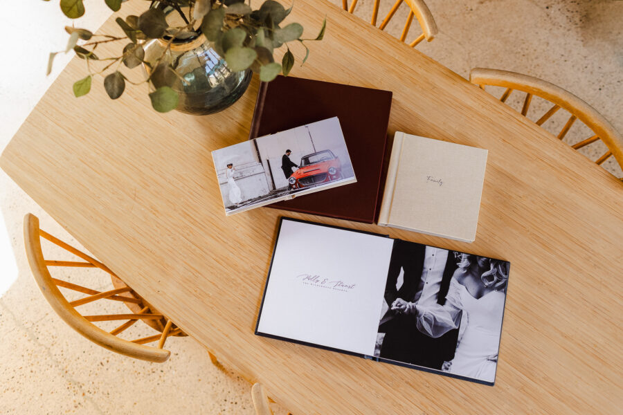 Wedding albums laid flat out on a dining room table showing the album sizes you can get