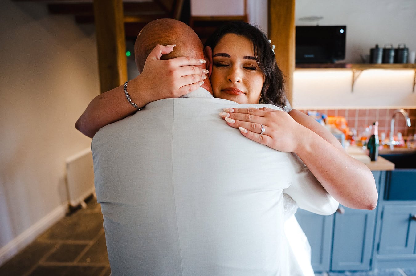 The bride and father have a hug after sharing their first look