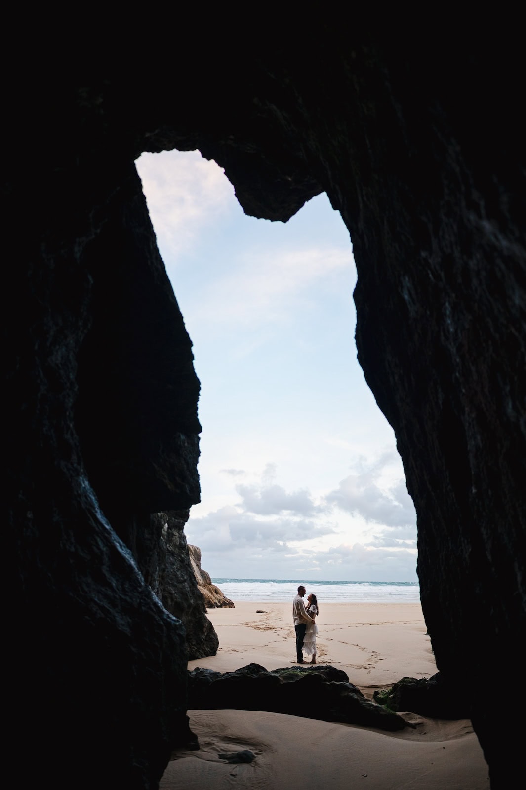 Looking from the cave out onto a beach in Cornwall as they celebrated their elopement - Cornwall Wedding Photography FAQs