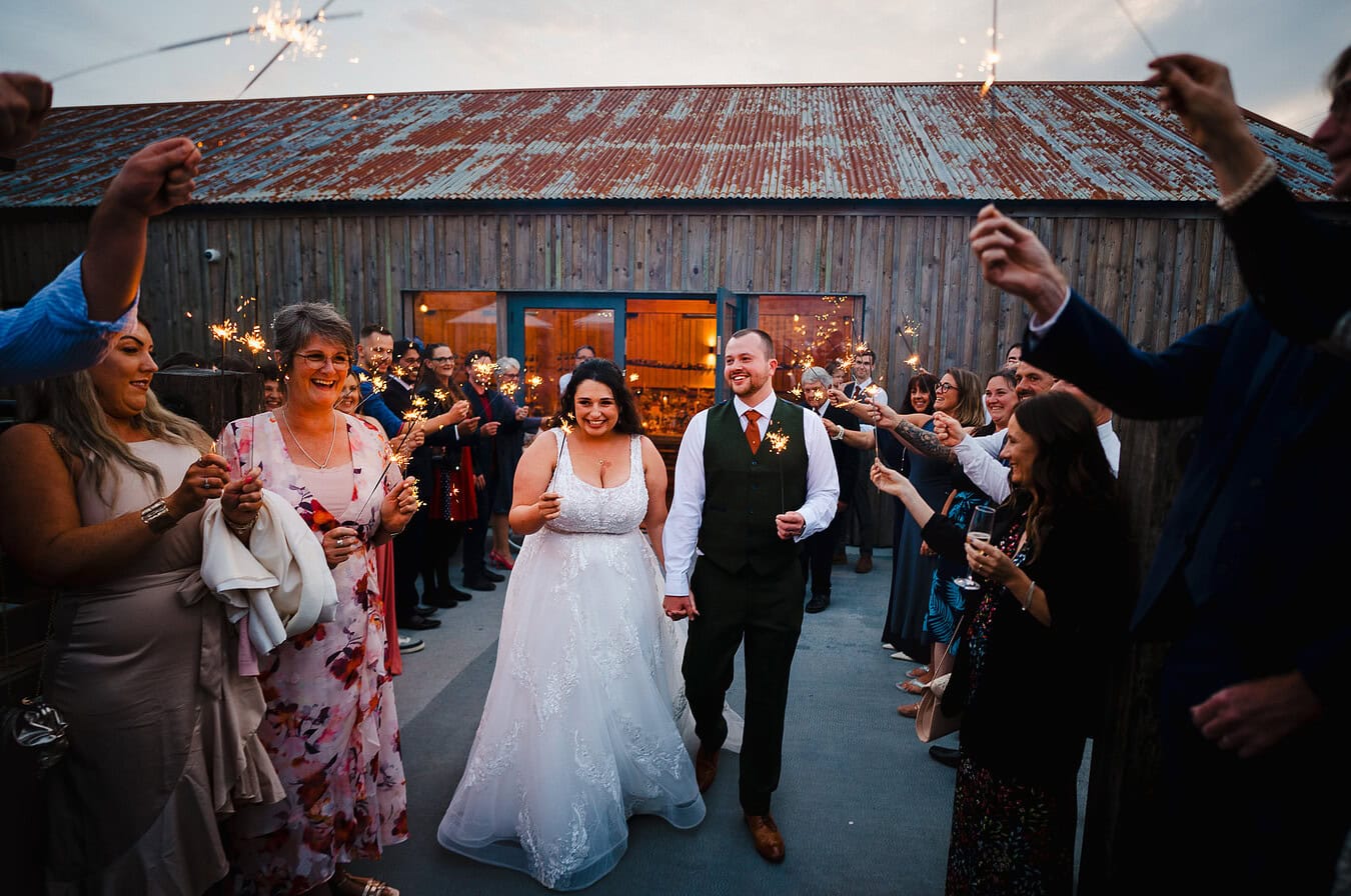 Couple walking with Sparklers through their sparkler arch at their Avalen Wedding in Cornwall by Jake Timms Photography