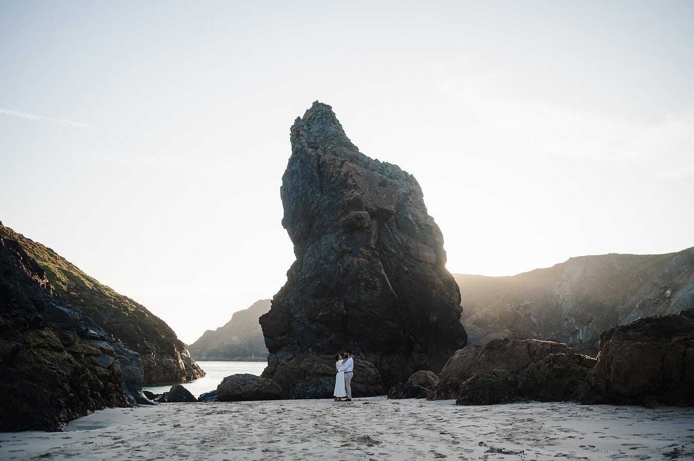 The dramatic rock stands out off the beach in Cornwall as the happy newly engaged couple celebrate