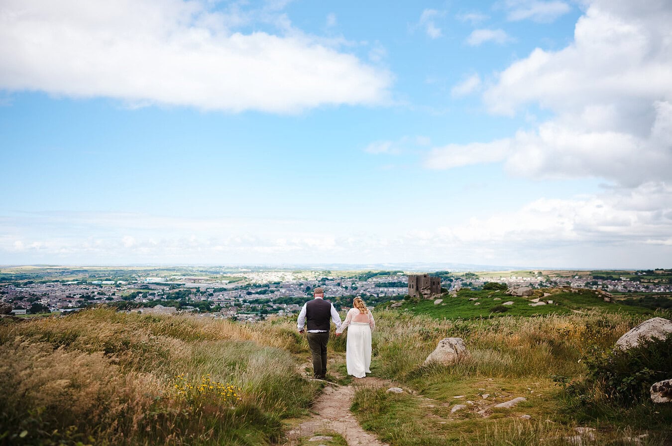 Ontop of the world as the happy newlyweds stand on the hill at Carn Brea, Cornwall