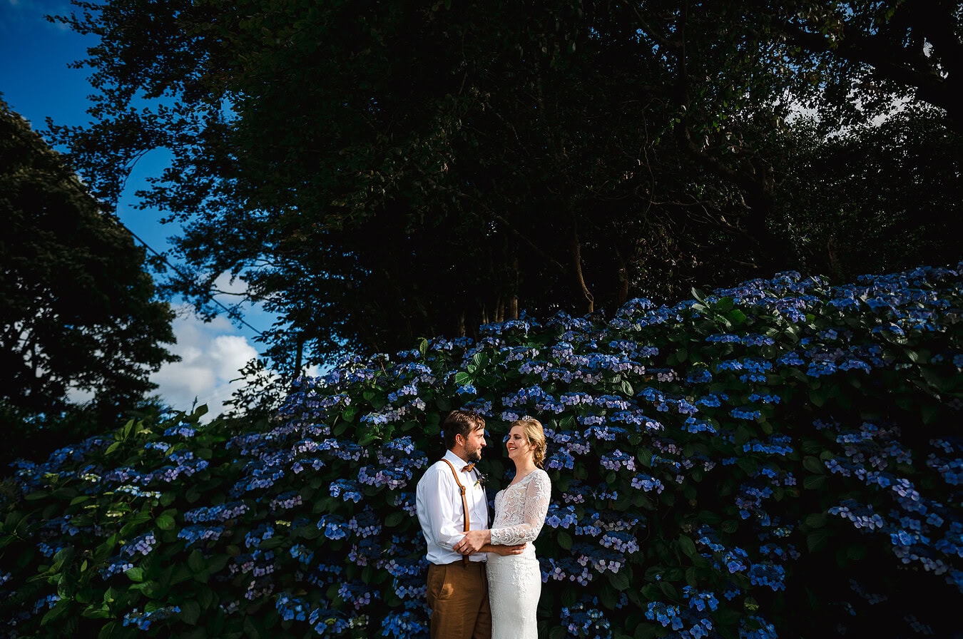 Standing against the beautiful blue flowers