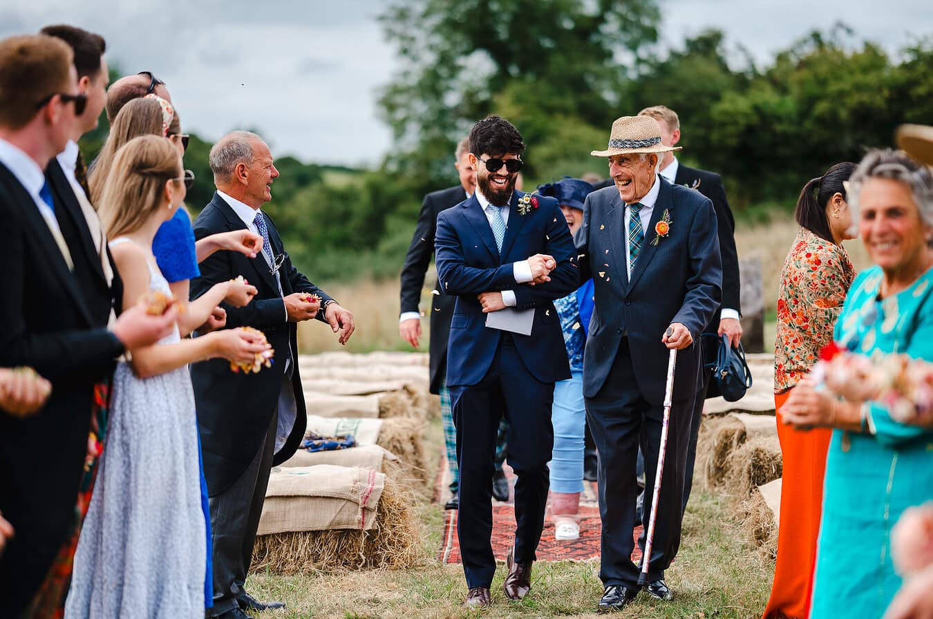 Wedding guests full of laughter as they get ready for wedding confetti