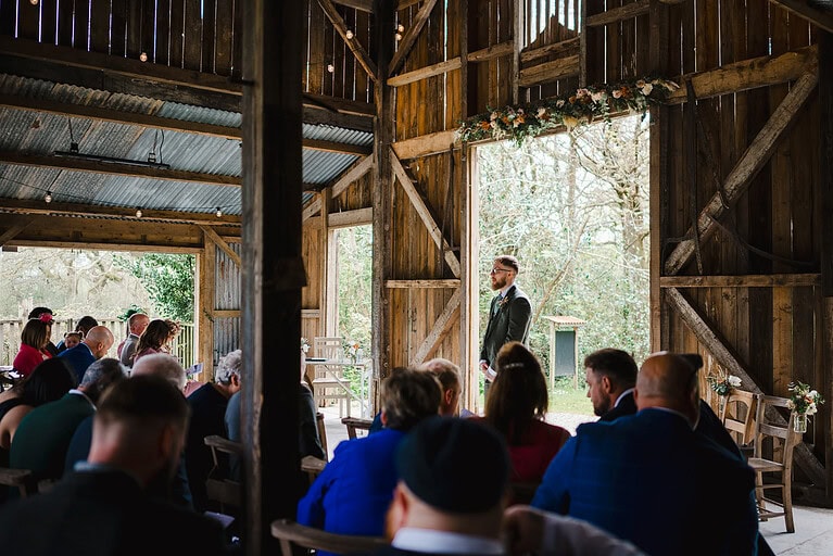 The groom waits for his bride in the wedding barn for their Nancarrow Wedding