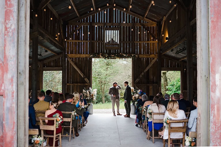 Surrounded by loved ones as the groomsmen wait for the bride in the wedding barn at Nancarrow farm