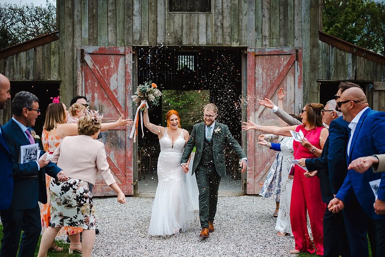 The newlyweds storm out of the wedding aisle to be covered in wedding confetti at their Nancarrow Wedding - By Nancarrow Wedding Photographer - Jake Timms Photography