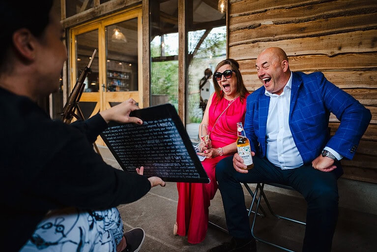 Wedding guests laugh in hysterics as they are shown their caricature