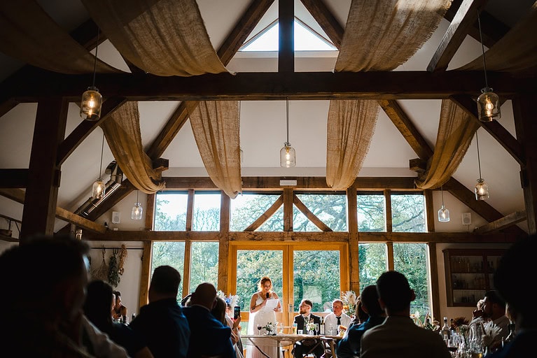 The wedding guests look and takes in the brides wedding speech at Nancarrow Farm By Nancarrow Wedding Photographer - Jake Timms Photography