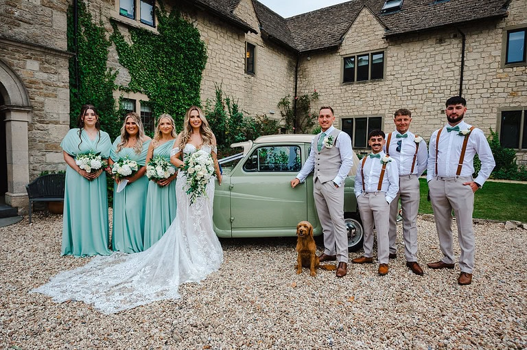 What a moment as the bridal party stand outside The Pear Tree Wedding Venue against the classic wedding car