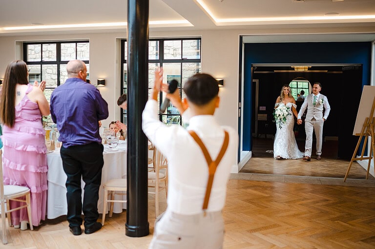 The bride and groom make their wedding entrance into the reception room into the Pear tree in Purton