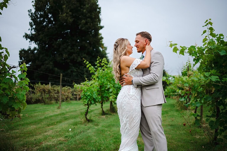 With the vineyards behind the happy couple stand tall for their couple photos at The Pear Tree In Purton