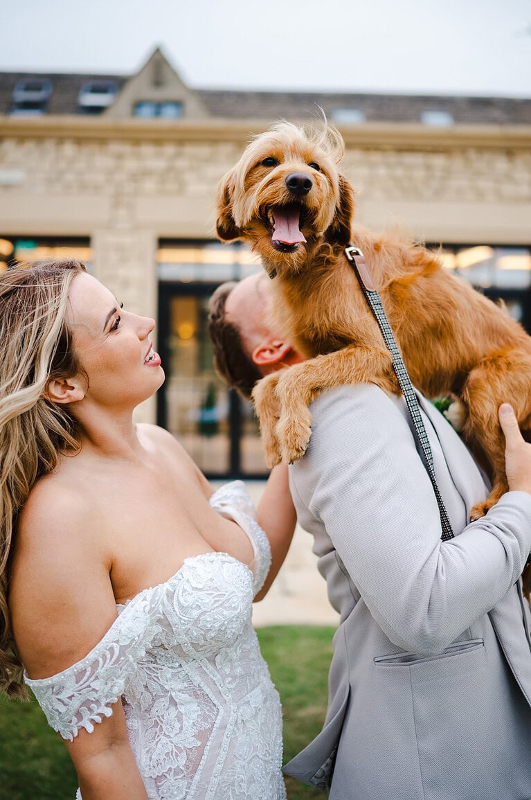 The dog perches himself on the grooms shoulder