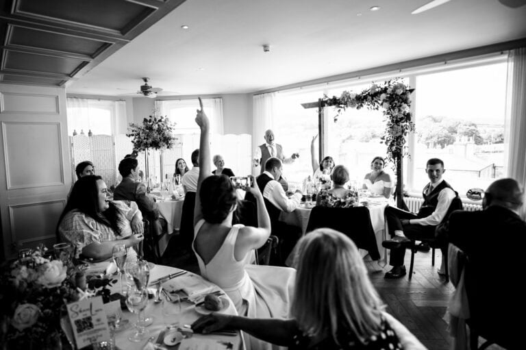 Wedding speeches as the guest raise their hands