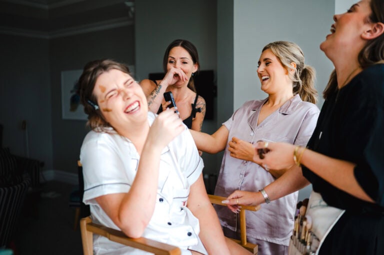 Fun and laughter as the bride gets ready as the bridesmaid shows a hysterical video to the wedding suppliers - Documentary wedding photography, By Jake Timms Photograhy