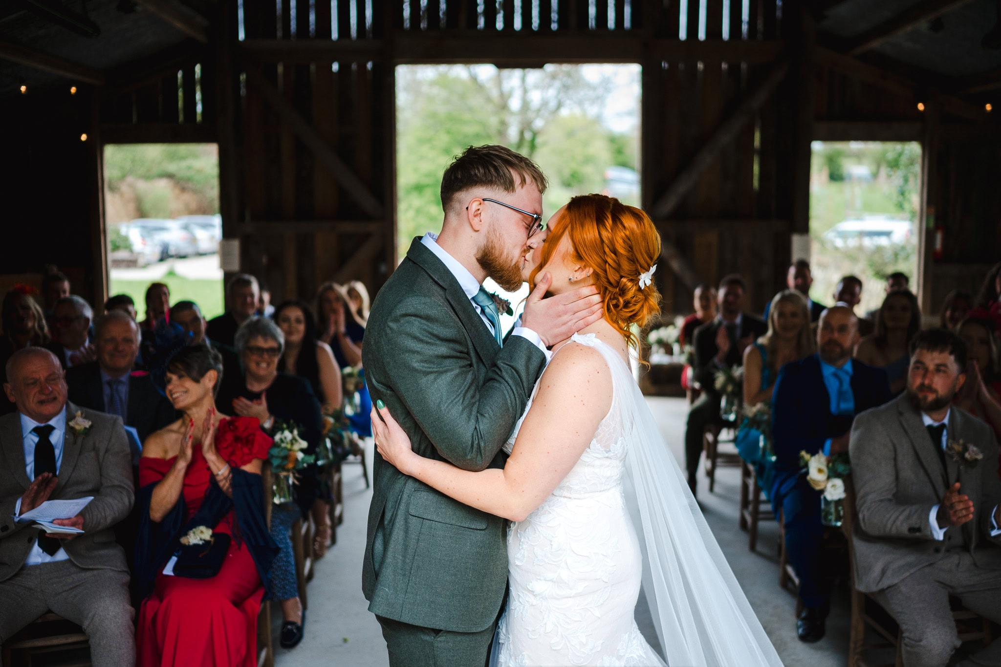 Bride and groom kiss as they are announced as husband and wife at Nancarrow farm by Cornwall wedding photographer, Jake Timms Photography | Wedding Video Portfolio