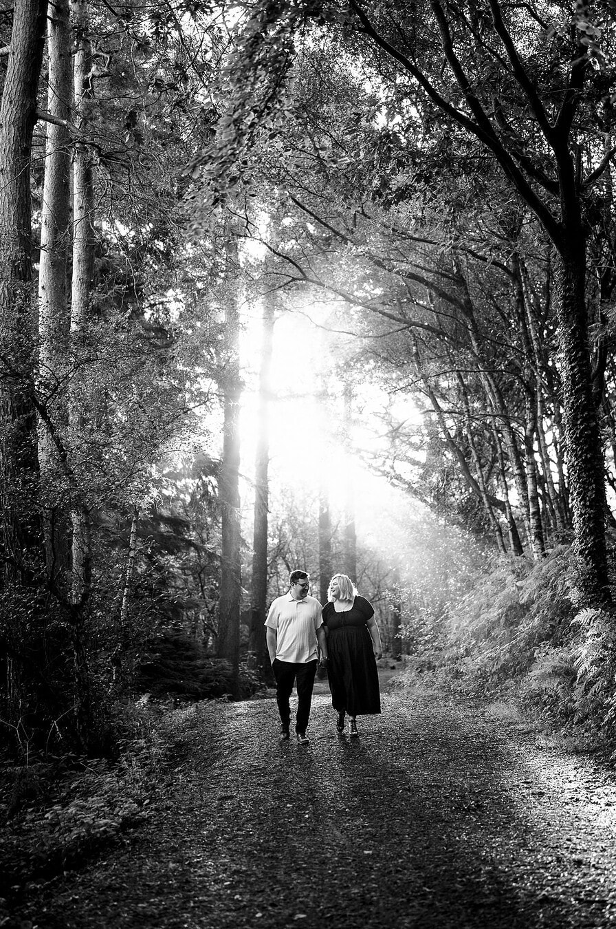 Walking through the woodland during their engagement celebration in Cheshire, by Jake Timms Photography